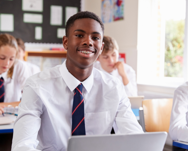 Young teen boy at school in the classroom.