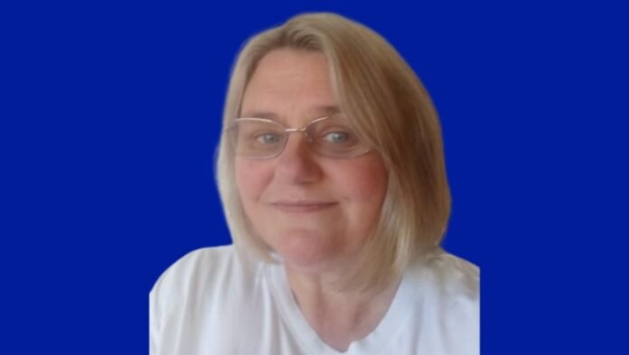 Response employee, Kathryn Woodham, wearing glasses and white t-shirt, smiling at the camera.