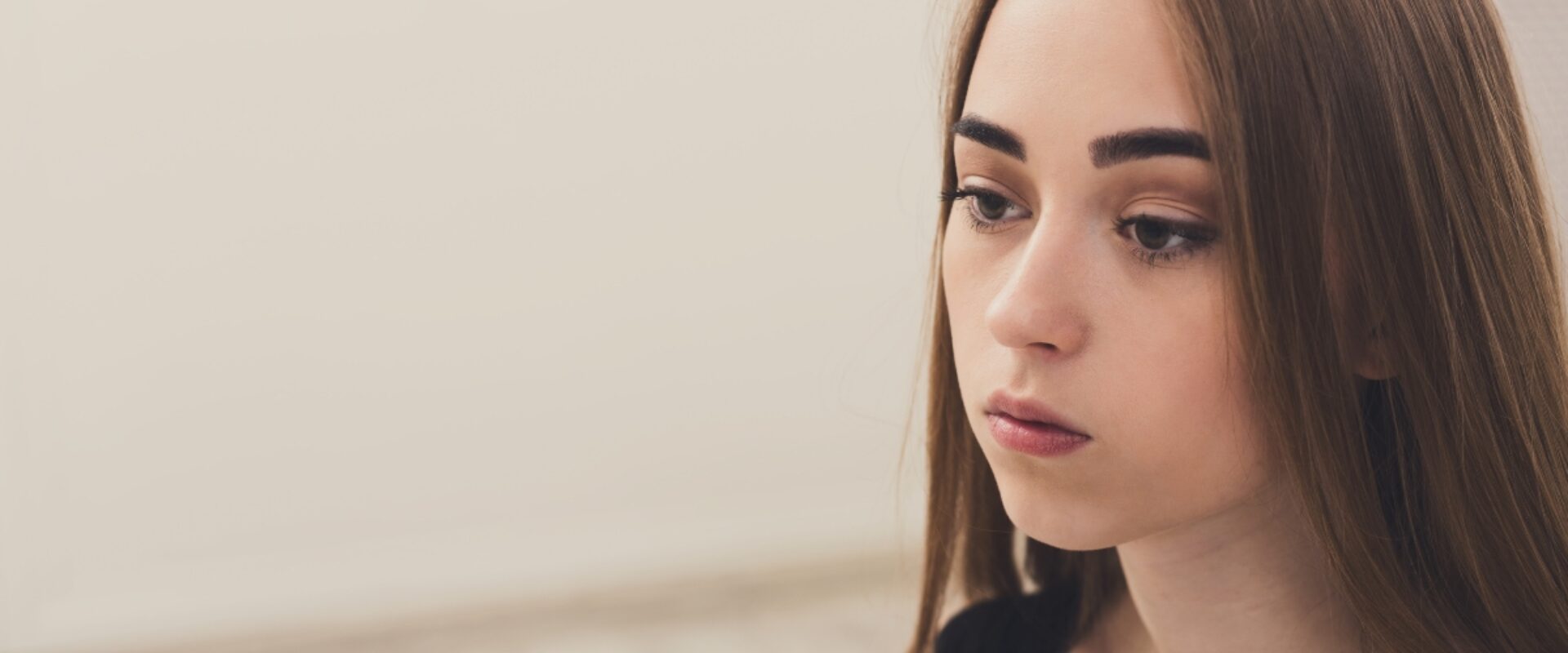 Young girl with dark brown hair looking glum.