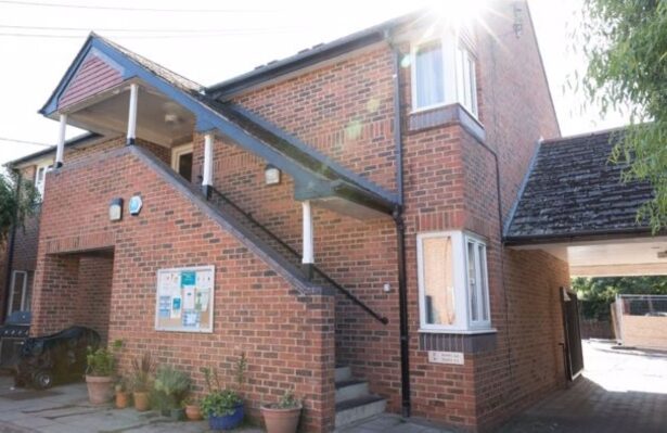 Image of the Newman Court building, which is red brick with white windows and a stairway.