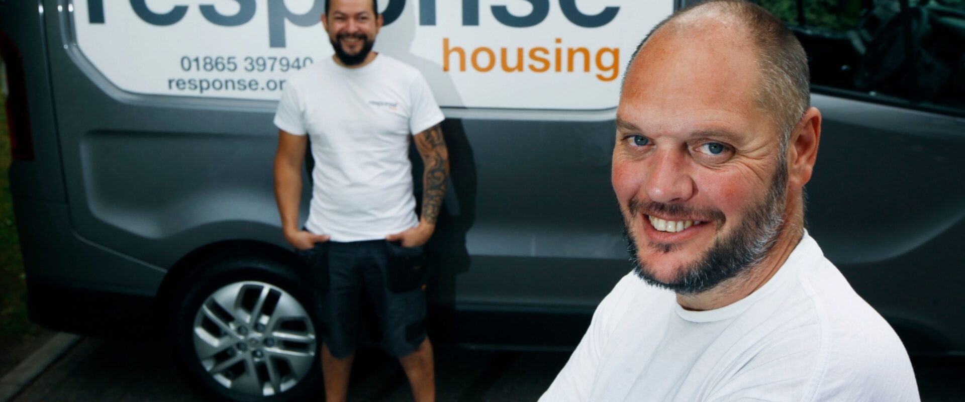 Response employees smiling in front of a Response branded van.