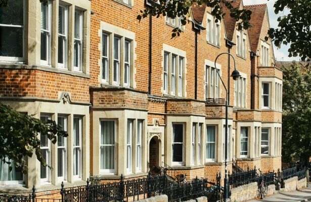 A row of Brick houses behind black gates.
