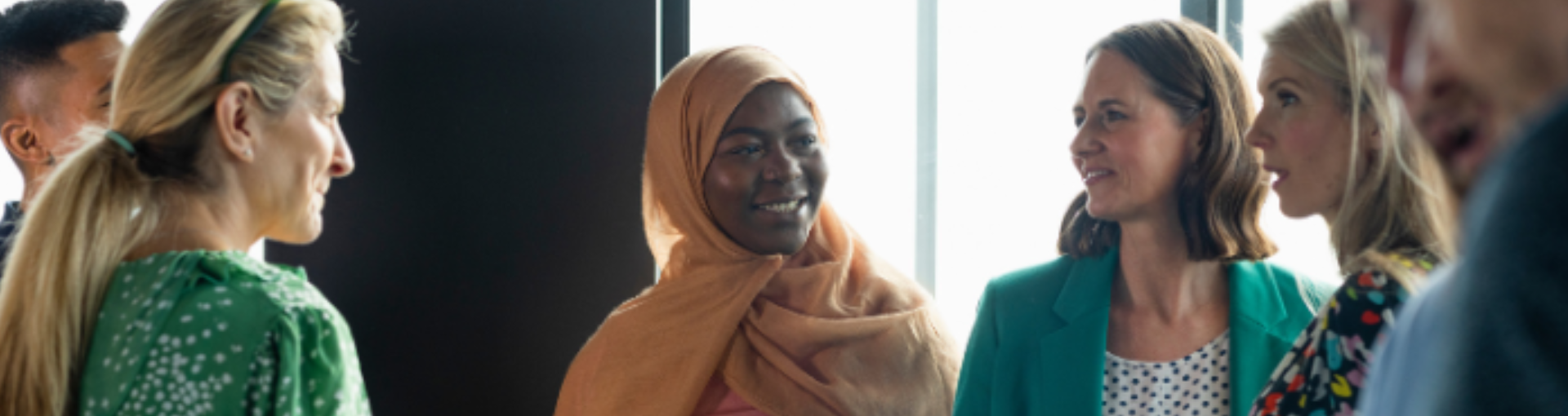 A diverse group of people standing and having a conversation.