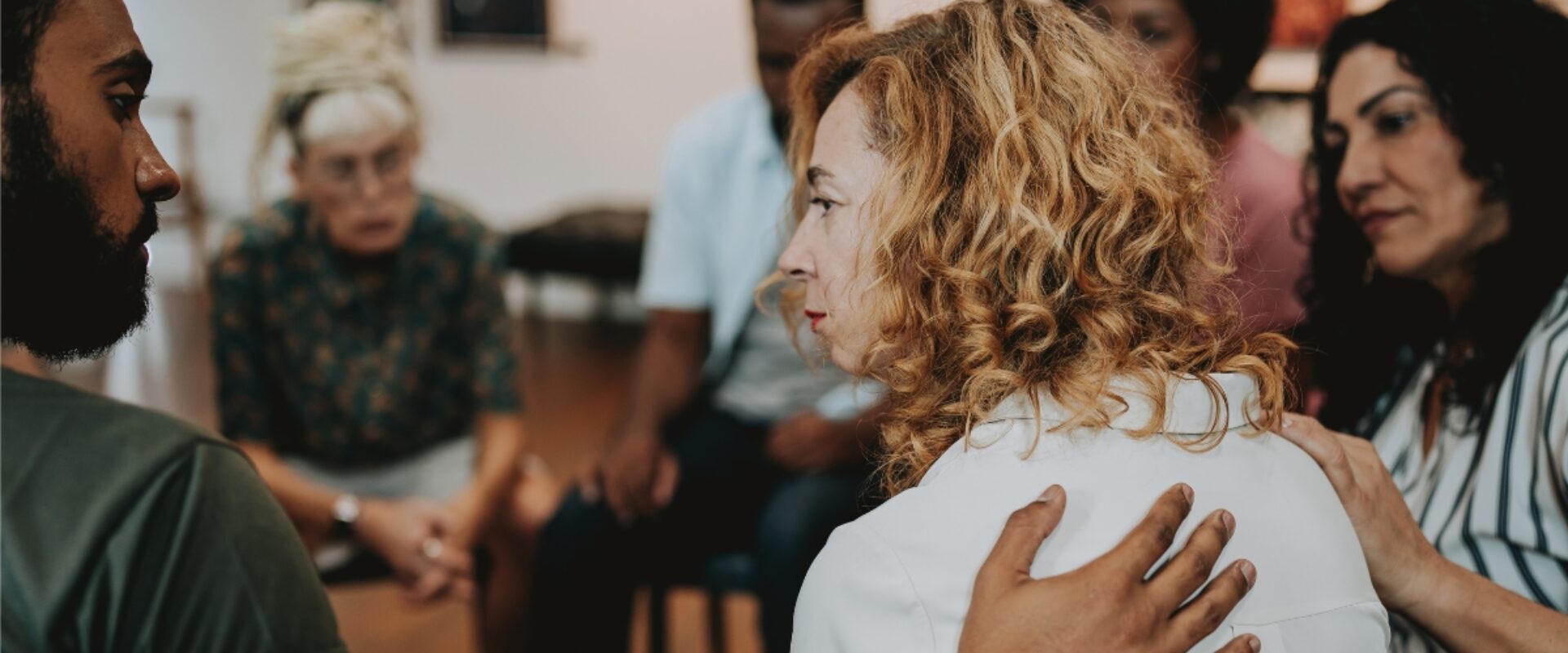 Group of people, comforting a sad looking woman.