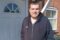 Response resident, Scott, in black hoodie stood in front of white door.